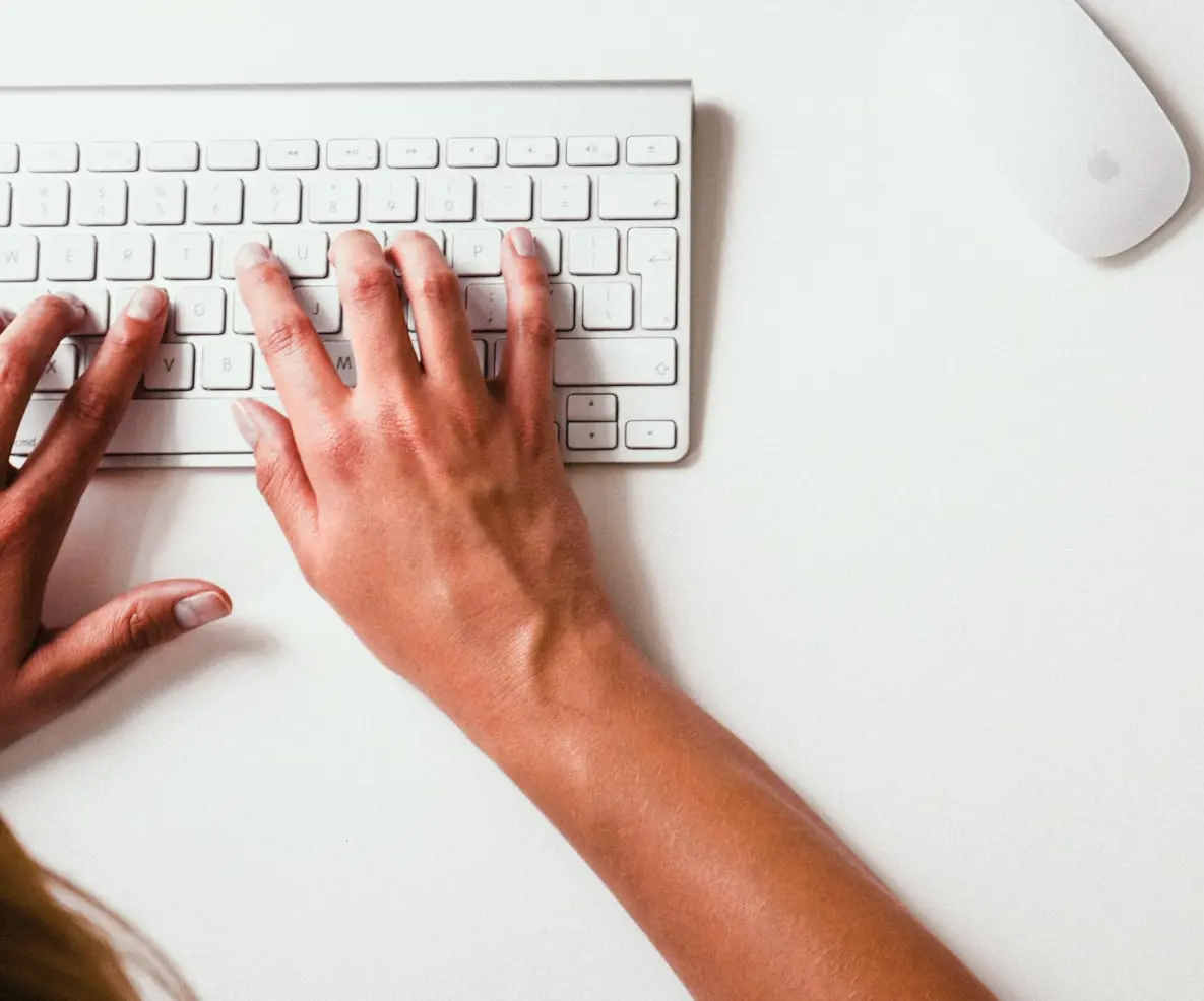 person typing on Apple Cordless Keyboard